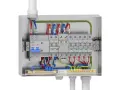 Wnętrze metalowej skrzynki z zabezpieczeniami i przewodami. Widoczna instalacja elektryczna z wyłącznikami, listwą zaciskową i uziemieniem.