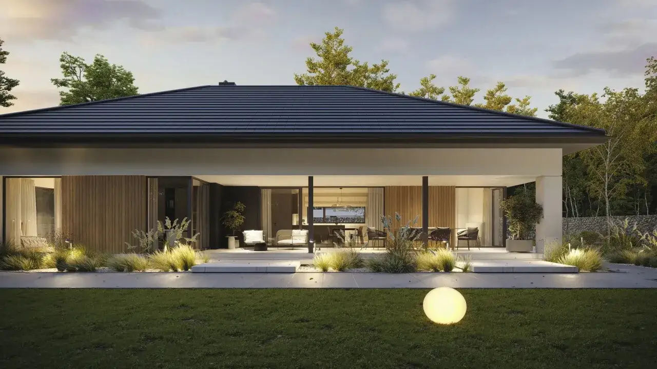 Nowoczesny bungalow z dużymi przeszkleniami i oświetlonym ogrodem.
